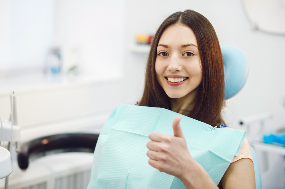 Satisfied patient sitting in a dental chair giving a thumbs up after a successful dental visit at Prescott Dental Arts in Prescott, AZ