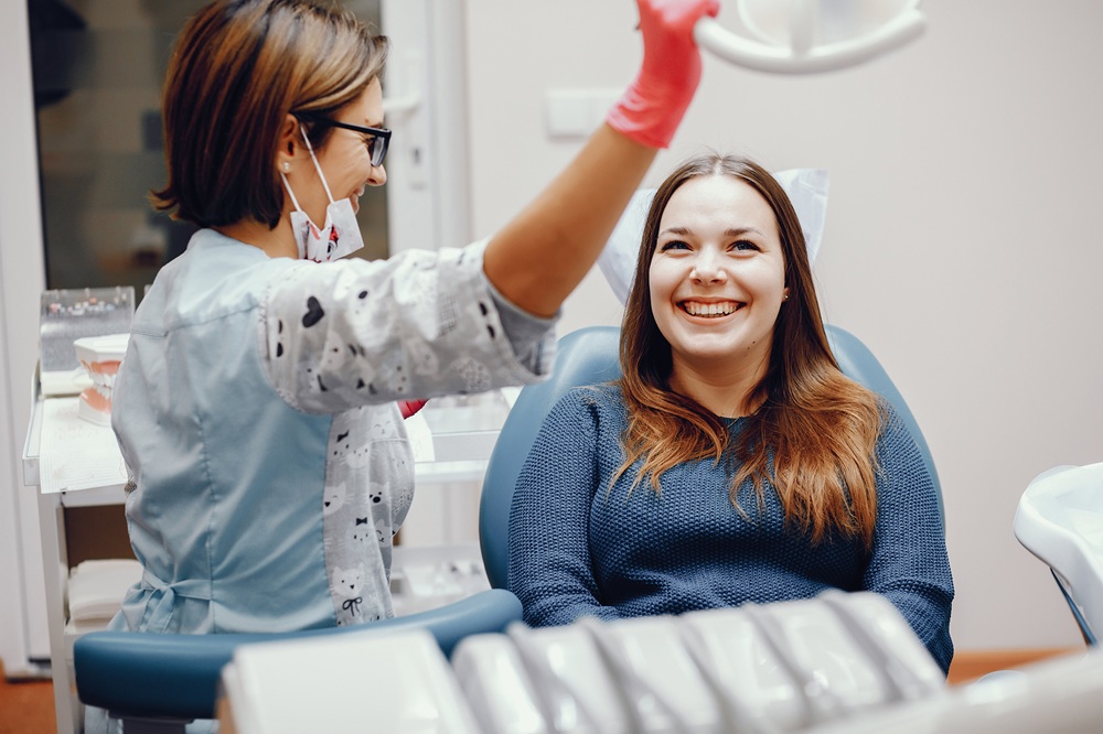 Comfortable Dental Implant Care, Dentist Prescott AZ Smiling female patient in a dental chair with a dental hygienist preparing treatment, representing the comfortable care experience at Prescott Dental Arts in Prescott, AZ