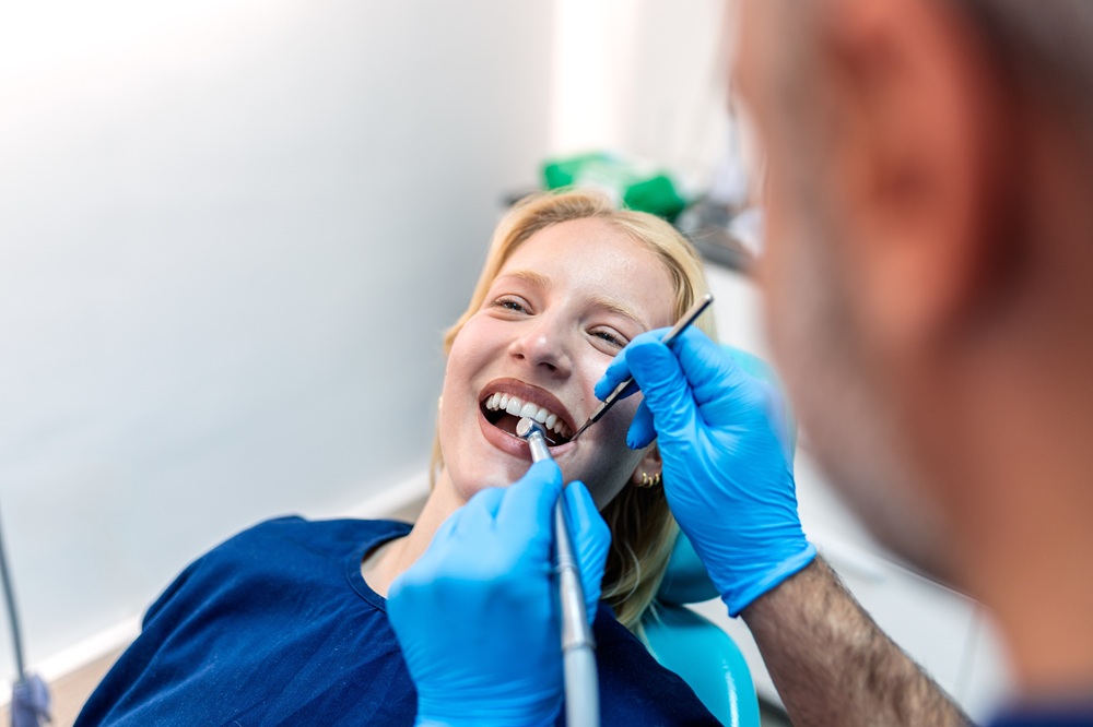 Female patient smiling during a dental procedure at Prescott Dental Arts in Prescott, AZ, with a dentist preparing placement of a zirconia dental implant