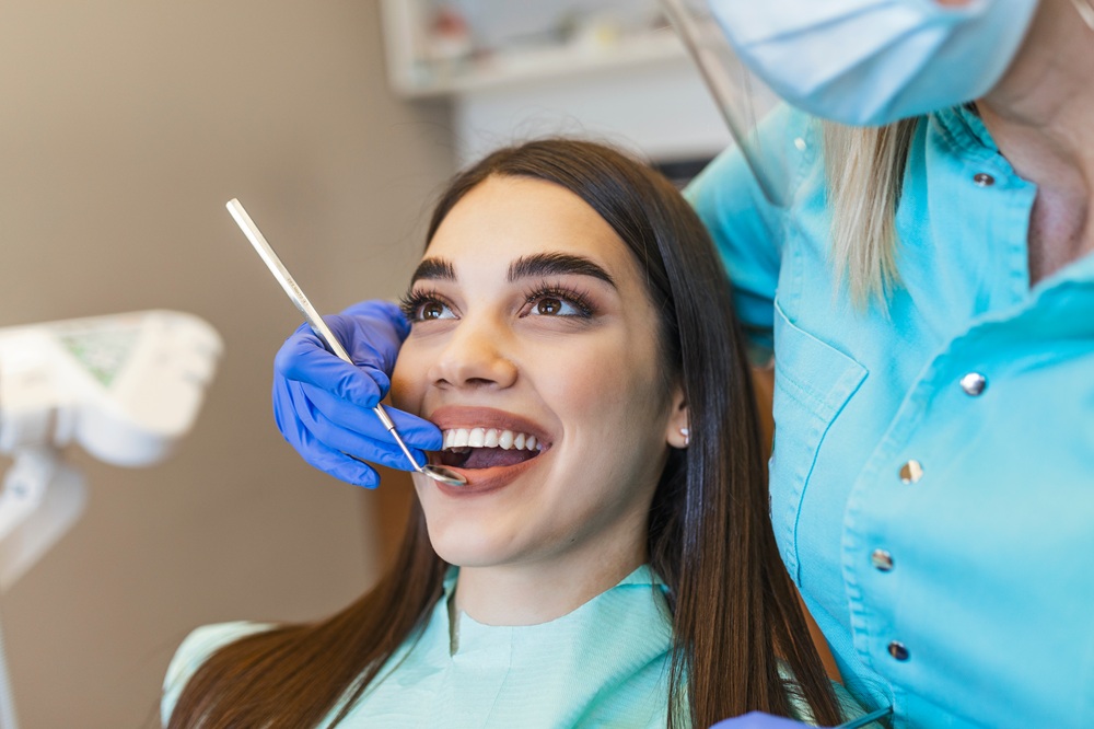 Porcelain Crown and Veneer Treatment, Dentist Prescott AZ Female patient smiling during a dental treatment at Prescott Dental Arts in Prescott, AZ, with a dental hygienist preparing to place a porcelain crown or veneer