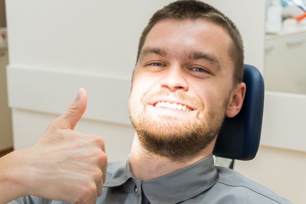 Satisfied Emergency Dental Patient, Emergency Dentist Prescott AZ Male patient giving a thumbs up in a dental chair after receiving emergency dental care at Prescott Dental Arts in Prescott, AZ