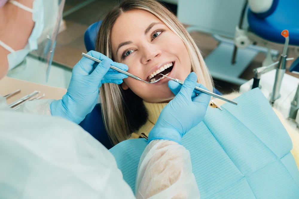 Relaxed female patient smiling during a dental examination at Prescott Dental Arts in Prescott, AZ, with a dentist performing a checkup before zirconia implant treatment