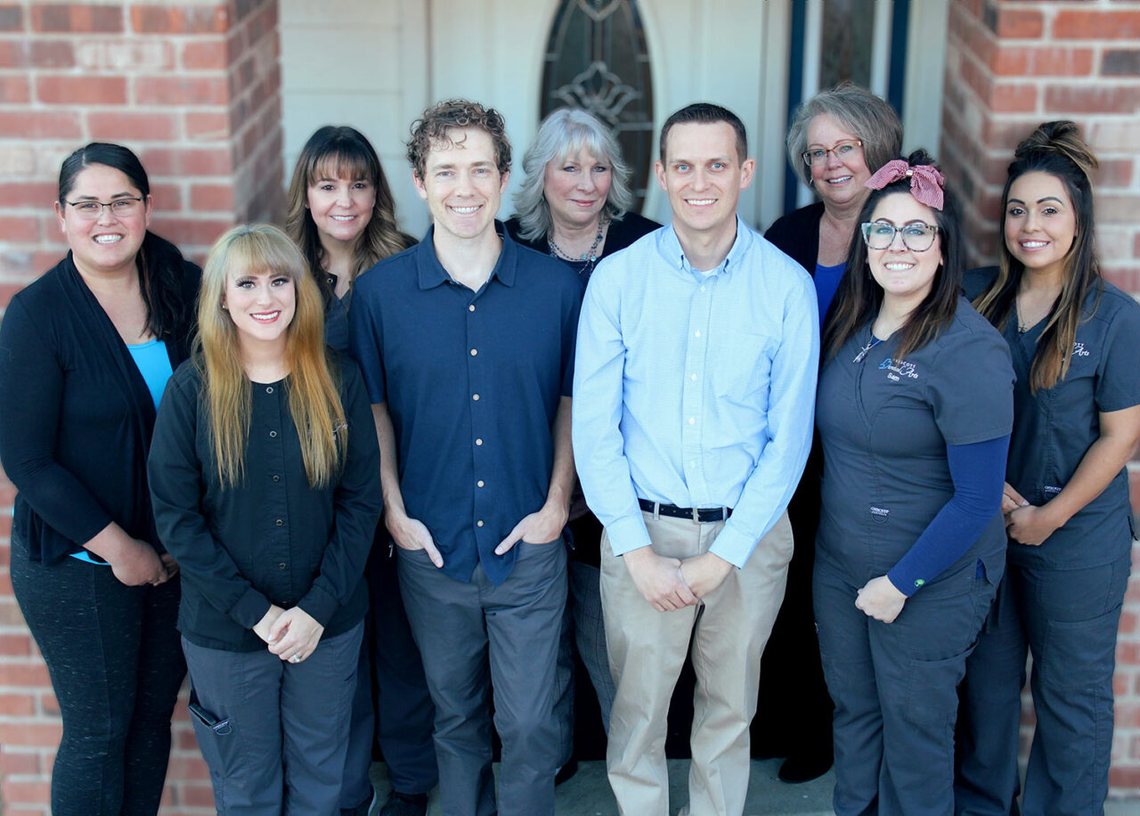 Meet the Prescott Dental Arts Team, Dentist Prescott AZ The dental team at Prescott Dental Arts smiling together outside the Prescott, AZ office entrance
